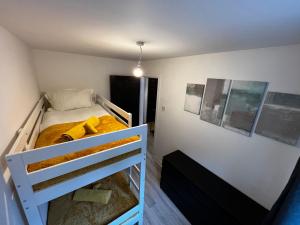 a small bedroom with a bunk bed with yellow blankets at Central flat, Alton Towers, Waterworld in Stoke on Trent