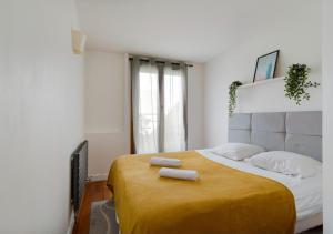 ein Schlafzimmer mit einem großen Bett mit zwei Handtüchern darauf in der Unterkunft Le CENTRE VILLE de Bezons in Bezons