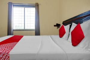 a bedroom with a large bed with red and white pillows at OYO Happy Homely Stay in Pune