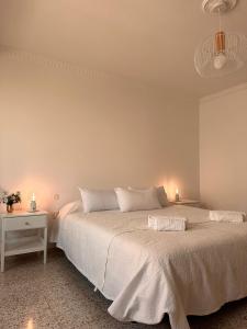 una camera da letto con un grande letto e un copriletto bianco di Ten minutes from airport a Vecindario