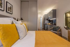 a bedroom with a large white bed with yellow pillows at Bonito Loft en Barrio de Chamberi Quevedo I in Madrid