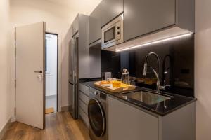 a kitchen with a sink and a washing machine at Bonito Loft en Barrio de Chamberi Quevedo I in Madrid