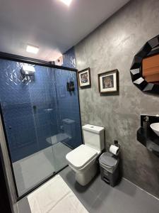 a bathroom with a shower and a toilet and a sink at Hotel La Serena in Maresias