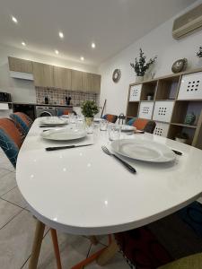 卡爾特漢的住宿－Cast'Azur - Appartement T3，厨房里一张白色的桌子,上面有盘子