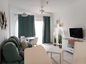 a living room with a green couch and a tv at Casa Paraiso in Los Cristianos