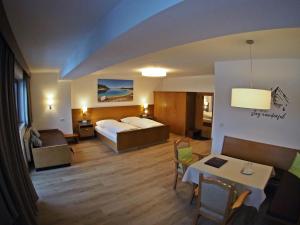 a hotel room with a bed and a living room at Hotel Egerthof in Seefeld in Tirol