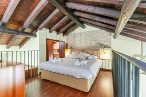 a bedroom with a large bed in a room with wooden ceilings at RHOme 24 - cozy attic at Rho Fiera in Rho