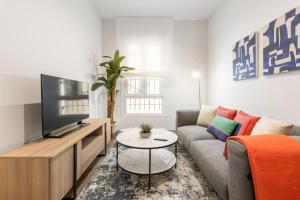 a living room with a couch and a tv at Apartamento para 4 en Chamberi Quevedo V in Madrid