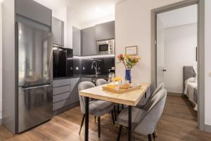 a kitchen with a table and chairs and a refrigerator at Apartamento para 4 en Chamberi Quevedo V in Madrid