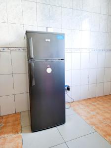a black refrigerator sitting in a room at Fefe's home in Dar es Salaam