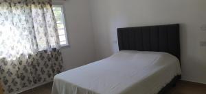 a bed in a bedroom with a window and a bedspread at Alquiler temporario zona sur MDQ in Mar del Plata