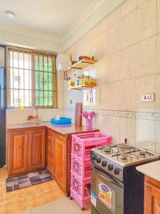 a kitchen with a stove and a pink stove top oven at Fefe's home in Dar es Salaam