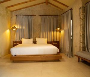 a bedroom with a large bed with white sheets at Zoe Hora in Dhërmi +79 photos