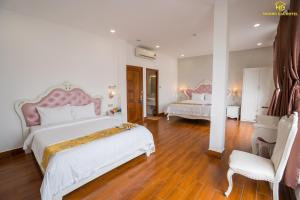 a large bedroom with two beds and a chair at Hoàng Gia Hotel Tuy Hoà in Tuy Hoa