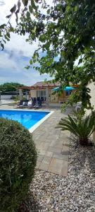 - une piscine avec des chaises et une maison dans l'établissement Happy House, à Zadar