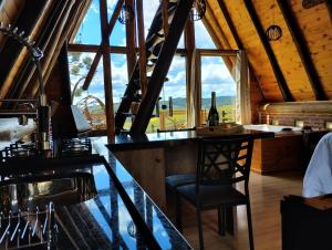 a bar with a table and a bottle of wine at Pousada Emerich in Cambará