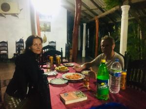 a man and a woman sitting at a table with food at Randiya Holiday Resort in Minneriya