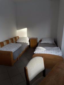 a room with two beds and a table and a chair at Noclegi Pracownicze LAZUR in Ciechanów