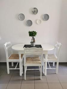 una mesa blanca y sillas con una maceta. en Nostalgia apts, en Limassol