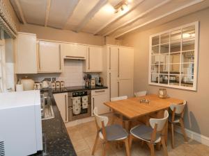 uma cozinha com uma mesa de madeira, uma mesa e cadeiras em 6 Hillside Terrace em Dartmouth