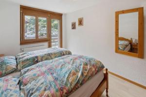 een slaapkamer met een bed en een spiegel bij Mountain whisper-4 pers. in Zermatt
