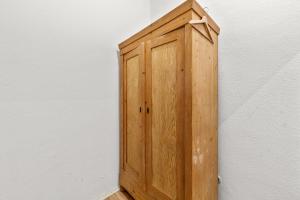 une armoire en bois assise sur le côté d'un mur dans l'établissement primeflats - Apartment Leberstr 58 Berlin Schöneberg, à Berlin