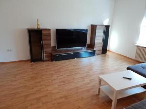 uma sala de estar com uma televisão de ecrã plano e uma mesa em Lea´s Apartment´s em Dortmund