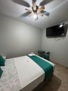1 dormitorio con ventilador de techo y 1 cama en Hotel Redinson, en Piura