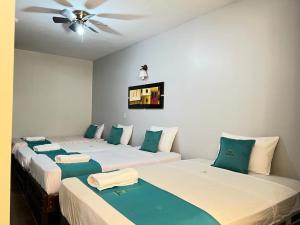 2 Betten in einem Zimmer mit Deckenventilator in der Unterkunft Hotel Redinson in Piura