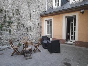 a patio with a table and chairs and a building at Superbe logement à proximité du centre et du Kirchberg in Luxembourg