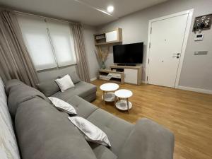 een woonkamer met een bank en een tv bij Villa Malena in Chiclana de la Frontera