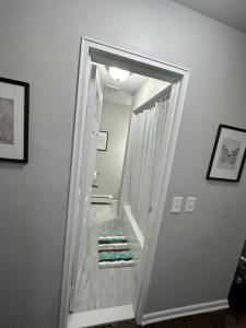 a hallway leading to a bathroom with a mirror at Cozy 2 BR suite, 10 min to NYC &Times Sq in West New York
