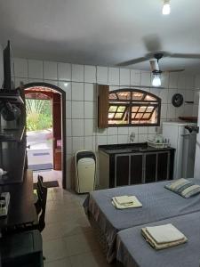 a room with two beds and a kitchen with a table at Pousada Nascente do Pirahy in Piraí