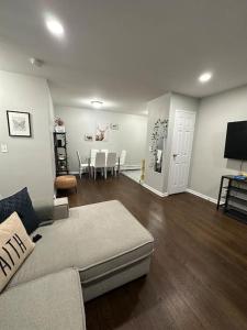 a living room with a couch and a dining room at Cozy 2 BR suite, 10 min to NYC &Times Sq in West New York +23 photos