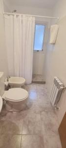 uma casa de banho branca com um WC e uma janela em Cactus Tempo em Esquel