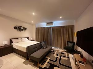 ein Schlafzimmer mit einem Bett, einem Sofa und einem Stuhl in der Unterkunft The signature premium studio (2) in Accra