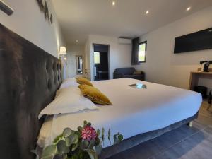 a bedroom with a large white bed with pillows at Hôtel Casa Mea in Bastia