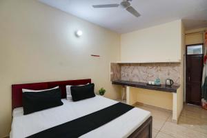 a bedroom with a large bed and a desk at OYO Hotel Vedant in Noida