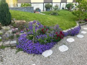 a garden with purple and purple flowers and rocks at La Petite Maison de Jane in Reims