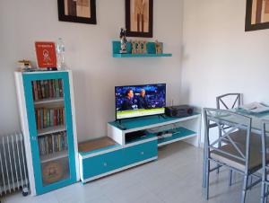 ein Wohnzimmer mit Fernseher und Tisch in der Unterkunft Casa Joleen 2 in Villamartin