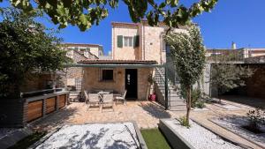 a courtyard of a house with a table and chairs at Splendid Gouvia Villa 3 Bedrooms Villa Yiarios Private Playground in Pouládes