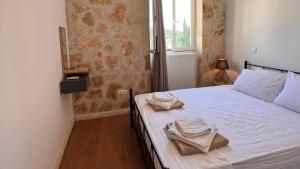 a bedroom with a bed with two towels on it at Splendid Gouvia Villa 3 Bedrooms Villa Yiarios Private Playground in Pouládes +17 photos