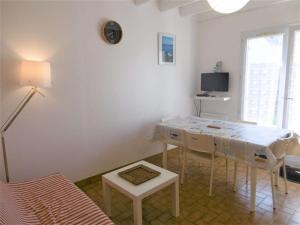 sala de estar blanca con mesa y TV en Maisonnette 3 pièces 4-5 personnes proche de l'océan - WIFI - Lenaig en Sarzeau