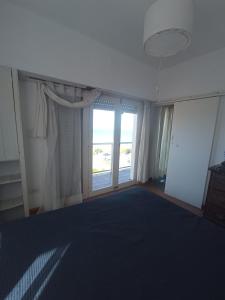 a living room with a large window and a large blue carpet at Departamento frente al mar 3 ambientes Playas de Surf in Mar del Plata