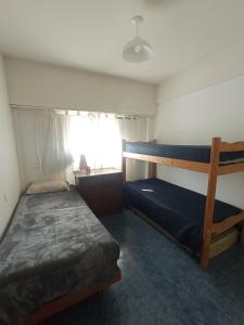 a bedroom with two bunk beds and a window at Departamento frente al mar 3 ambientes Playas de Surf in Mar del Plata