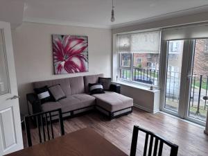 a living room with a couch and a table at Cosy Spacious 2 bed flat Hornchurch high street in Hornchurch
