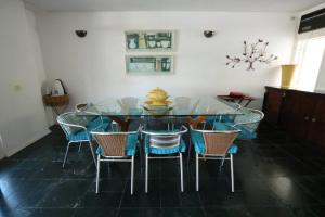 a dining room with a glass table and chairs at Casa em Jardim Acapulco-Guarujá in Guarujá