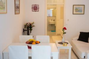 una sala de estar con una mesa con un bol de fruta en Apartments Škarpa en Malinska