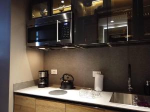 a kitchen with a microwave and a coffee maker on the counter at Luxury Loft Chico Piscina etc. in Bogotá