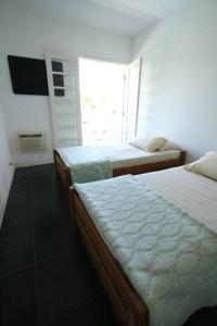 a bedroom with two beds and a window at Casa em Jardim Acapulco-Guarujá in Guarujá